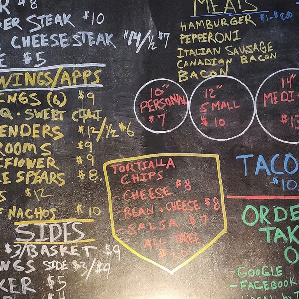 Colorful chalkboard menu lists hamburgers, wings, appetizers, sides, meats, taco pizza, and takeout ordering information.